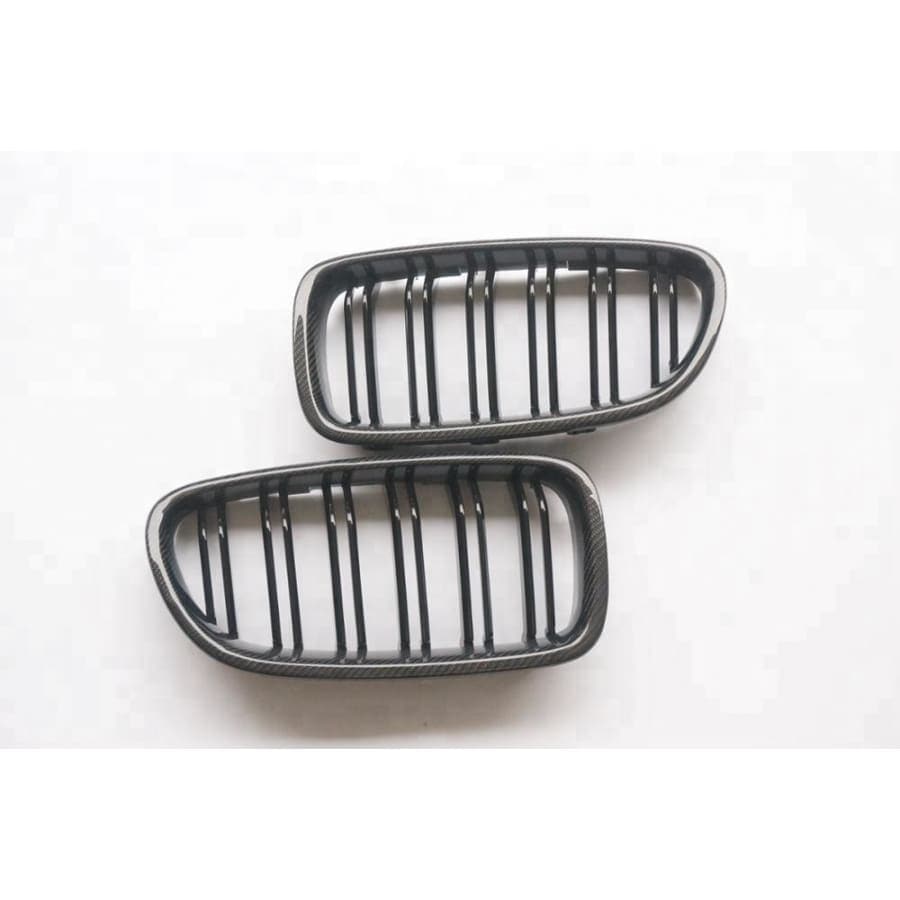 BMW X5/X5M/X6/X6M Carbon Fibre M Style Front Grilles - Comprised of gloss black dual inner slats made from ABS plastic with a 2*2 Carbon fibre outer ring that adds a touch of carbon to the front end of your X5 or X6 Model. This product will come with the X5M or X6M Badges, depending on which model you choose.